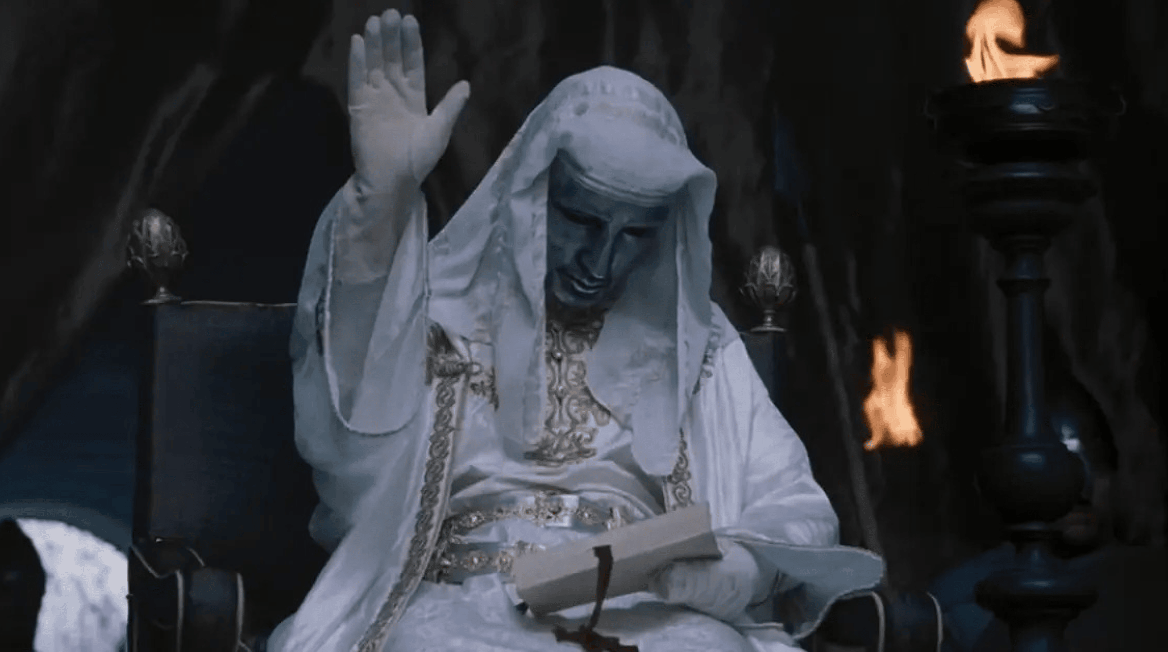 A masked king with a raised right hand